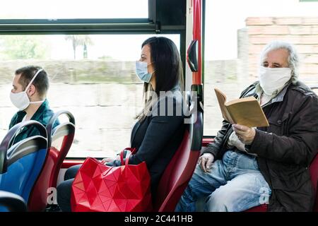 Passagiere mit Schutzmasken im öffentlichen Bus, Spanien Stockfoto