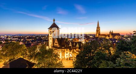 Deutschland, Baden-Württemberg, Freiburg im Breisgau, Panorama des beleuchteten Schwabentor-Tores bei Dämmerung Stockfoto