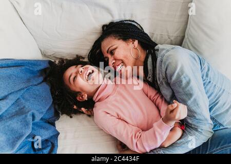 Mutter und kleine Tochter auf der Couch zu Hause Spaß haben Stockfoto