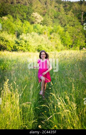 Portrait von kleinen Mädchen lächelnd, während er in Richtung Kamera über Landschaft Wiese Stockfoto