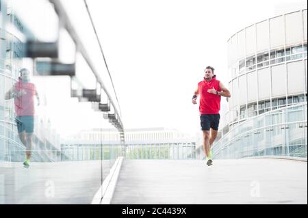 Junger Mann beim Joggen auf dem Steg in der Stadt Stockfoto