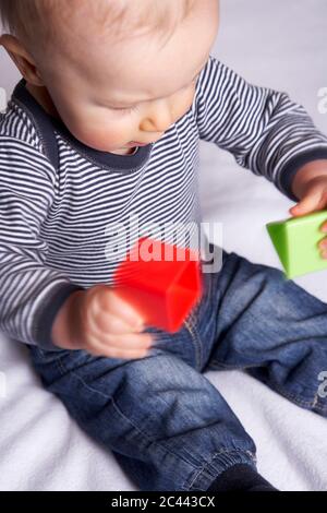 Baby auf einer Decke spielt mit Bausteinen Stockfoto