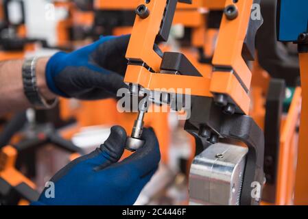 Detail des Menschen, der an einer Maschine in einer Fabrik arbeitet Stockfoto