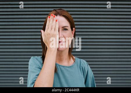 Frau, die ein Auge mit ihrer Hand bedeckt Stockfoto