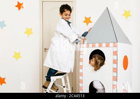 Geschwister spielen Astronaut und Forscher bei Rocket Stockfoto