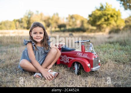 Portrait von kleinen Mädchen mit Pedal Auto in der Natur Stockfoto