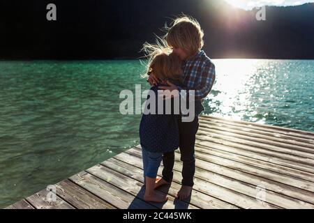 Bruder küsst Schwester während er auf der Promenade am Achensee, Tirol Land, Österreich steht Stockfoto