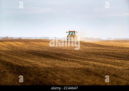 Landwirt im Traktor Pflügen Feld im Frühjahr Stockfoto