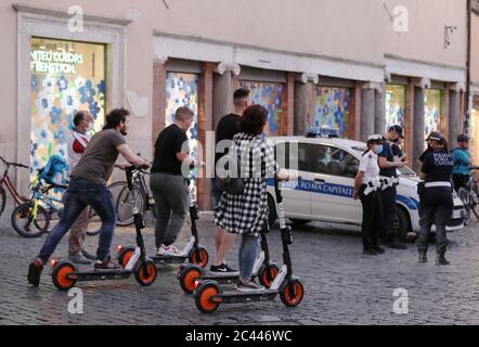 Rom, Italien. Juni 2020. Menschen fahren Elektroroller in Rom, Italien, 23. Juni 2020. Da Italien weiterhin die Regeln der Coronavirus-Sperre lockdown lockdown, Fußgänger, die auf die Straße zurückkehren, finden sich im Wettbewerb um Platz mit einer Art von Fahrzeug, das kaum im Land vor der Sperre - Elektro-Scooter gab.ZUM THEMA "Feature: E-Scooter geben in italienischen Stadtstraßen inmitten Pandemie, nicht alle zufrieden' Credit: Cheng Tingting/Xinhua/Alamy Live News Stockfoto