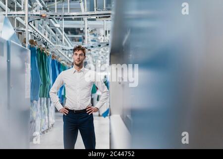 Porträt eines selbstbewussten jungen Geschäftsmannes in einer Fabrik Stockfoto