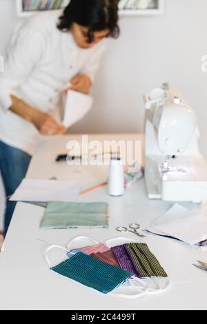 Hausgemachte bunte Schutz Gesichtsmasken auf dem Tisch von Frau zu Hause arbeiten Stockfoto