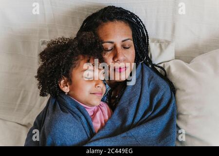 Portrait der Mutter und ihrer kleinen Tochter, die auf der Couch liegt Stockfoto