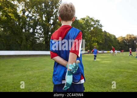 Fußballjunge in Uniform auf dem Feld stehend Stockfoto