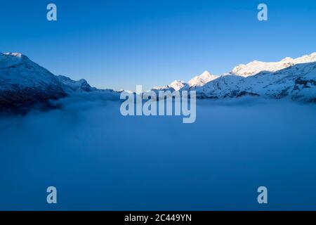 Schweiz, Kanton Graubünden, St. Moritz, Drohne Blick auf den Silvaplana-See und den Sils-See, der von dichtem Morgennebel umhüllt ist Stockfoto