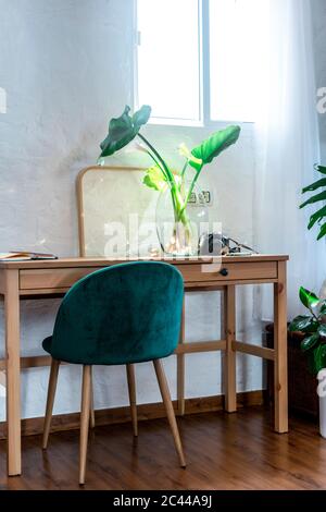 Stuhl und Schreibtisch gegen Fenster im Schlafzimmer zu Hause Stockfoto