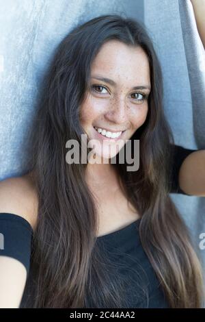 Nahaufnahme Porträt einer lächelnden jungen Sommersprossen Frau gegen Vorhang zu Hause Stockfoto