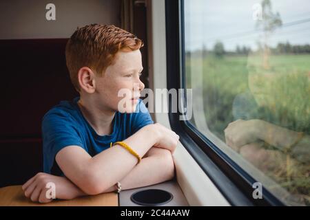 Junge, der durch das Fenster schaut, während er im Zug, Thailand, Asien reist Stockfoto