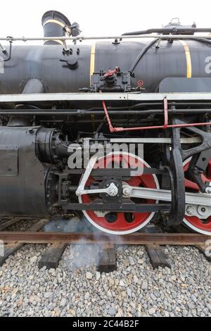 Nahaufnahme eines Fahrrads einer altmodischen Dampfeisenbahn mit rot-schwarz lackiertem Lack Stockfoto