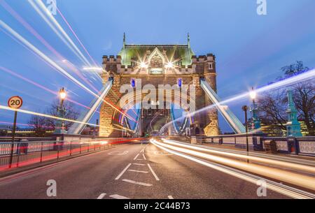 Der Eingang zur Tower Bridge in London mit dem verwacklungsunscharfen Verkehr vorbei Stockfoto