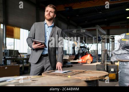 Junger Geschäftsmann mit Tablet in einer Fabrik Stockfoto