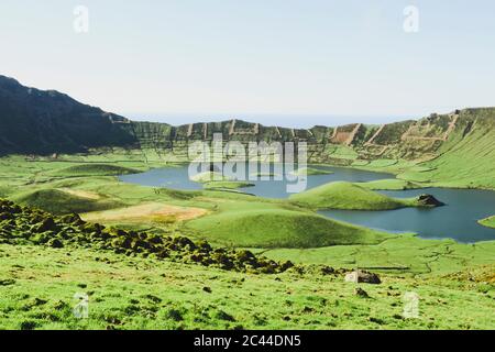 Landschaftlich schöner Blick auf den See inmitten von Bergen gegen klaren Himmel an sonnigen Tagen, Corvo, Azoren, Portugal Stockfoto