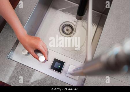 Hand der Frau, die den Wasserhahn in der Küche abdrehte Stockfoto