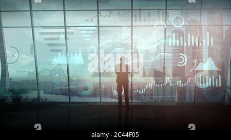 Ein Geschäftsmann, der in seinem Büro steht, arbeitet mit einer Reihe von Infografiken. Stockfoto