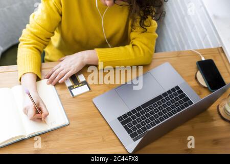 Nahaufnahme einer Frau, die im Home Office am Schreibtisch arbeitet und Notizen gemacht hat Stockfoto