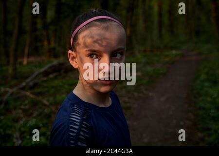 Nahaufnahme Seitenansicht des Mädchens, das im Wald wegschaut Stockfoto
