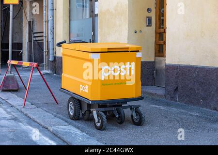 Moderner E-Mail-Trolley der finnischen Posti vor einem Wohnhaus in Helsinki, Finnland Stockfoto