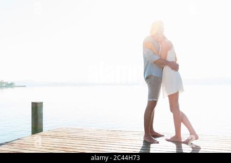 Glückliches junges Paar umarmt sich gegenseitig auf dem Steg Stockfoto