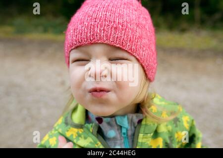 Portrait von Kleinkind Mädchen mit geschlossenen Augen pouting Mund Stockfoto