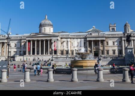 LONDON, Großbritannien - 18. JULI 2015: Teil des Trafalgar Square in London während des Tages. Brunnen, die Nationalgalerie und Menschen können gesehen werden. Stockfoto