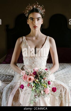 Junge Frau trägt Hochzeitskleid mit Strauß Stockfoto