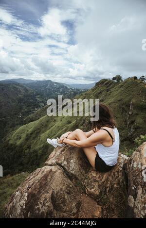 Sri Lanka, Uva Province, Ella, weibliche Wanderer auf Felsbrocken am Little Adams Peak sitzen Stockfoto
