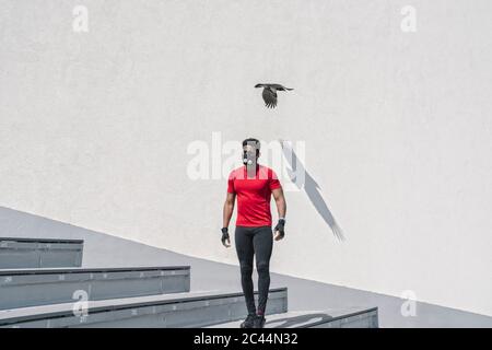 Sportler mit Maske und Vogelflug Stockfoto