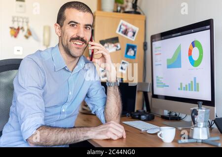 Mann, der von zu Hause aus telefoniert Stockfoto