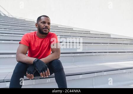 Sportler, der auf der Treppe sitzt und eine Pause hat Stockfoto