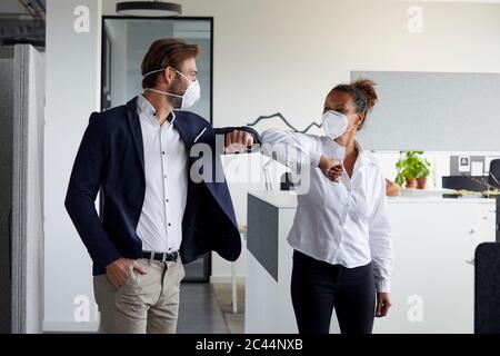 Kollegen begrüßen sich im Büro während der Corona-Krise Stockfoto