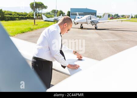 Pilot macht vor dem Flug Inspektion auf seinem Sportflugzeug Stockfoto