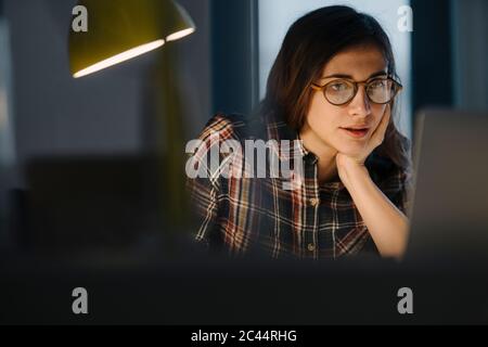 Portrait von jungen Freiberufler am Abend auf Laptop arbeiten Stockfoto