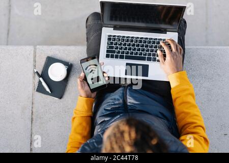 Draufsicht auf Mann mit Laptop und Smartphone für Online-Shopping Stockfoto