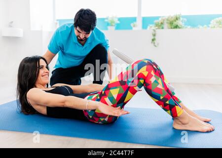 Sehbehinderte männliche Physiotherapeutin, die Frau in der Klinik behandelt Stockfoto