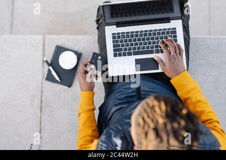 Draufsicht auf Mann mit Laptop und Kreditkarte für Online-Shopping Stockfoto