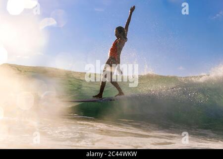 Weibliche Surfer balancieren auf Surfbrett Stockfoto