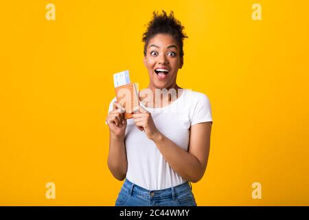 Begeisterte afro-Frau, die Tickets und Reisepass hält Stockfoto