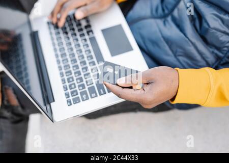Nahaufnahme eines Mannes, der Laptop und Kreditkarte zum Online-Shopping verwendet Stockfoto