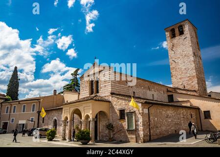 1. Juni 2019 - Foligno, Perugia, Umbrien, Italien - die Basilika Santa Maria Infraportas, eine alte mittelalterliche Kirche, mit ihrem Turm. Die gelbe Flagge Stockfoto
