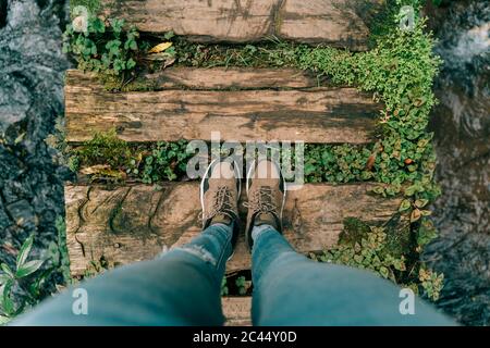 Blickpunkt Aufnahme einer Frau, die auf der Promenade über einem Bach auf der Insel Sao Miguel, Azoren, Portugal, steht Stockfoto