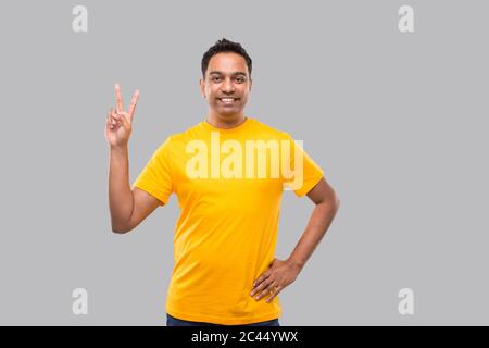 Indischer Mann zeigt Friedenszeichen isoliert smilling Stockfoto